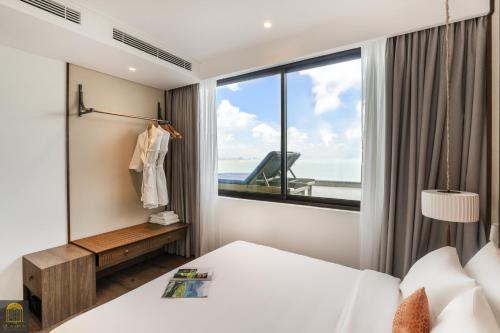 a bedroom with a bed and a large window at Mandala Pearl Azure Retreat in Ấp Nhơn Long