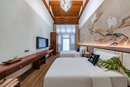 a bedroom with a large bed and a tv at Lishè Hotel in Pingyao