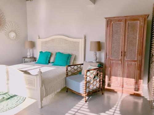 a bedroom with a white bed with blue pillows at Villa S in Hua Hin