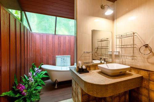 un bagno con vasca, lavandino e vasca da bagno di Swankiri Resort สวอนคีรี รีสอร์ท a Pong Yaeng