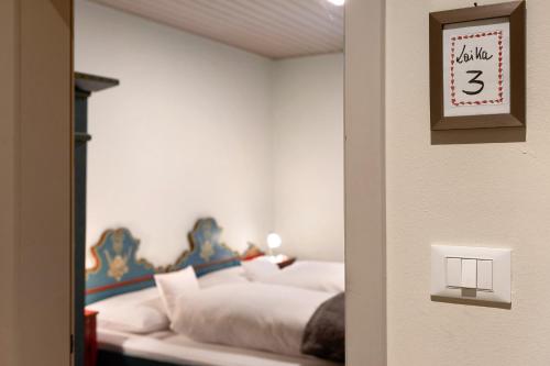 a bedroom with two beds and a clock on the wall at Alter Fausthof in Fie allo Sciliar