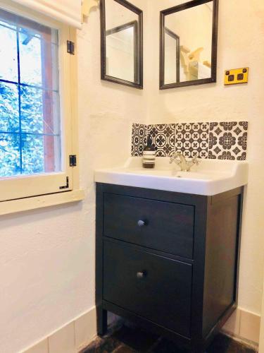 a bathroom with a black and white sink and a window at KW Hacienda in Upper Sturt