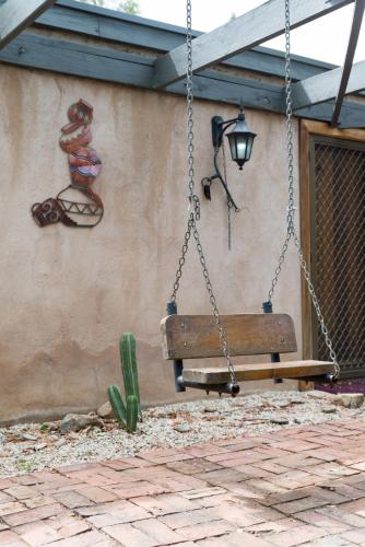 a swing hanging from a wall with a cactus at KW Hacienda in Upper Sturt