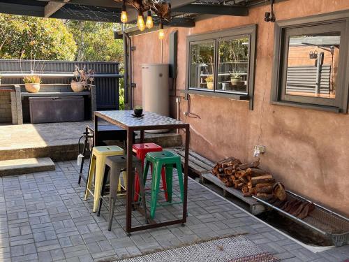 a patio with a table and some colorful stools at KW Hacienda in Upper Sturt