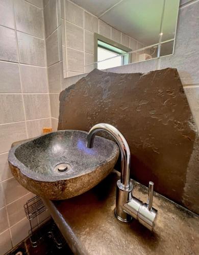 a stone sink in a bathroom with a mirror at KW Hacienda in Upper Sturt