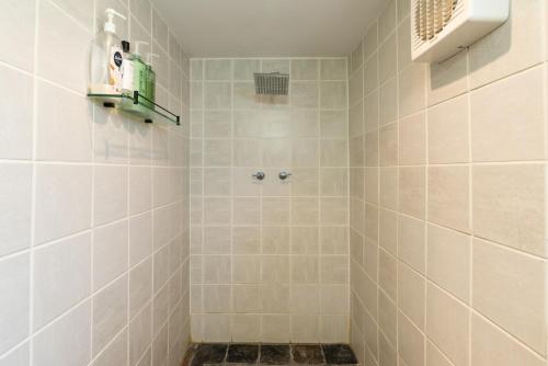 a bathroom with a shower with white tiles at KW Hacienda in Upper Sturt