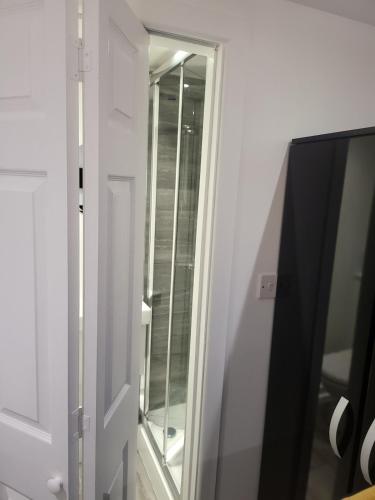 a mirror next to a door in a room at Evabrite Homes in Dartford