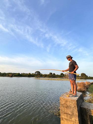 a man standing on a block holding a fishing pole at Hide Yala in Tissamaharama
