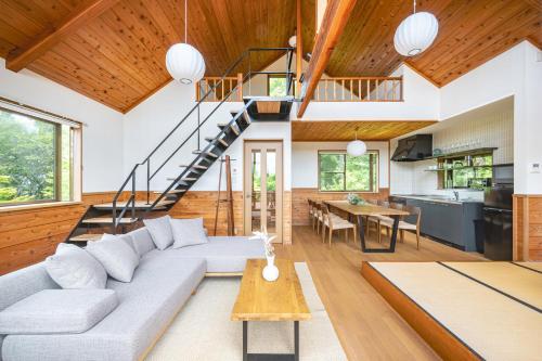 a living room with a couch and a staircase at プライベートリゾート富士 in Yamanakako