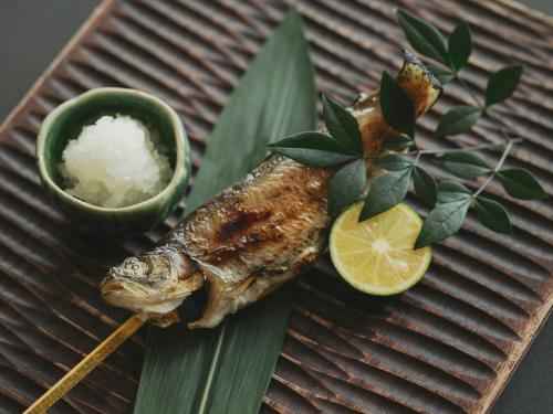 a fish on a plate with a chopstick and lime at SOKI ATAMI in Atami