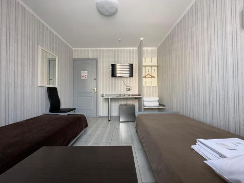 a hotel room with two beds and a desk at Hotel Almaz in Poltava