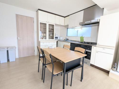 a kitchen with a wooden table and chairs at Chateau Sunrise in Tokyo