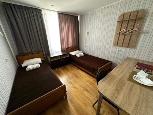 a small room with two beds and a table at Hotel Almaz in Poltava