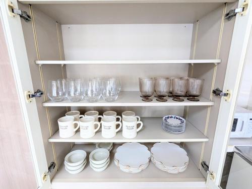 a cupboard filled with plates and cups and dishes at Chateau Sunrise in Tokyo