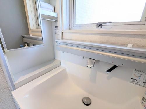 a bathroom with a sink and a window at Chateau Sunrise in Tokyo
