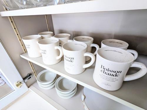 a bunch of coffee mugs sitting on a shelf at Chateau Sunrise in Tokyo
