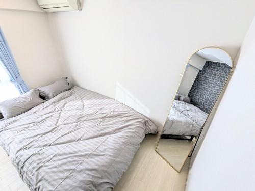 a small bedroom with a bed and a mirror at Chateau Sunrise in Tokyo