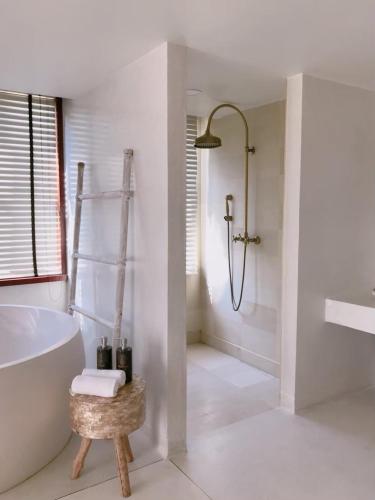 a white bathroom with a tub and a shower at Villa S in Hua Hin