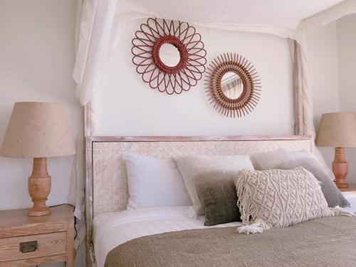 a bedroom with a bed with two mirrors on the wall at Villa S in Hua Hin