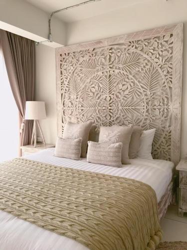a bedroom with a large bed with a large headboard at Villa S in Hua Hin