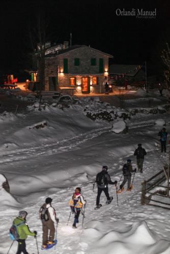 a group of people skiing in the snow at night at Rifugio Luna Nascente in San Martino