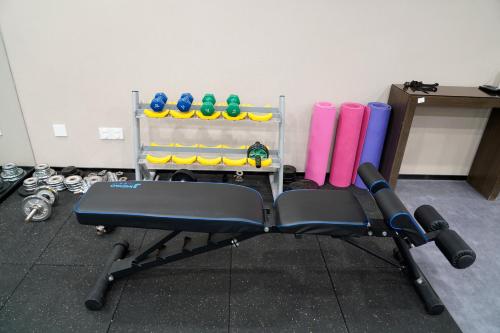 a gym bench with a rack of gym equipment at Aurum International Hotel Xi'an in Xi'an