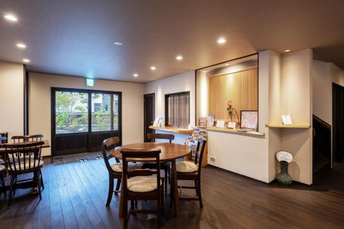 a dining room with a table and some chairs at うり房旅館仲通り うら房 in Kusatsu