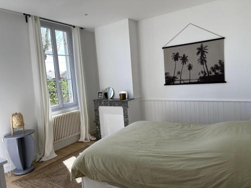 - une chambre avec un lit et une photo de palmiers dans l'établissement La Villa Louise, à Andernos-les-Bains