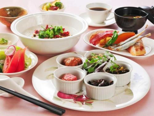 a table with plates of food and bowls of food at 奥伊勢フォレストピア in Ema