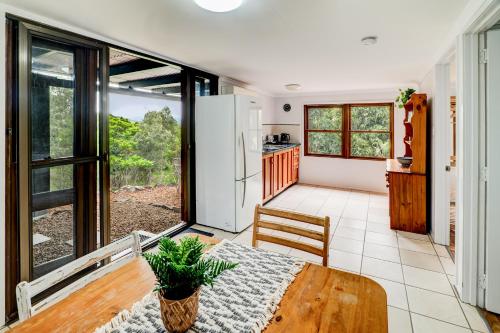 a kitchen and dining room with a table and a refrigerator at The Archer Retreat in Villeneuve