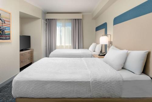 a hotel room with two beds and a television at Homewood Suites by Hilton Bonita Springs, FL in Bonita Springs