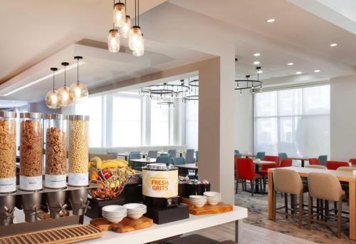 a dining room with tables and chairs and a counter with food at Hilton Garden Inn Shreveport in Shreveport
