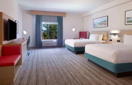 a hotel room with two beds and a flat screen tv at Hilton Garden Inn Shreveport in Shreveport