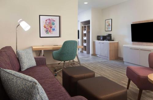 a living room with a couch and a desk with a chair at Hilton Garden Inn Shreveport in Shreveport