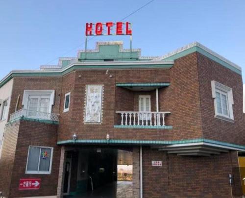a red brick building with a hotel sign on it at ホテル オアシス in Fukaya