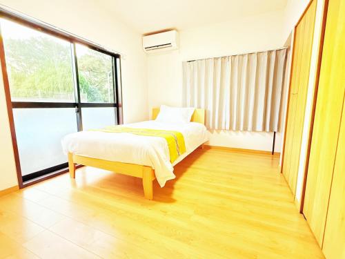 a bedroom with a bed and a large window at 西戸崎6丁目13番3号 in Fukuoka