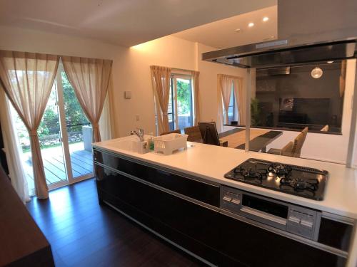 a kitchen with a stove and a counter top at 美ら海水族館まで車で3分の好立地ジャグジー付きの1棟貸Suppai Resort Okinawa in Motobu