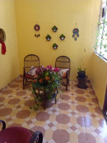a room with two chairs and a vase of flowers at Ashavis Hotel Pvt Ltd in Māvelikara