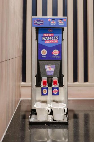 a coffee machine with three cups on a counter at Hampton By Hilton Vienna City West in Vienna