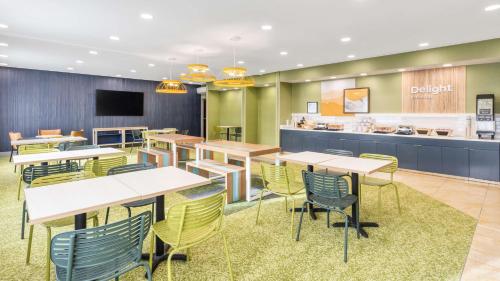 Un comedor con mesas y sillas y una cafetería. en Spark by Hilton Salt Lake City Airport, en Salt Lake City