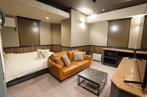 a living room with a couch and a bed at AND hotel in Fukushima
