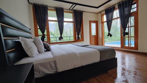a bedroom with a large bed with a large window at Sanctuary Resort Hunza in Hunza Valley
