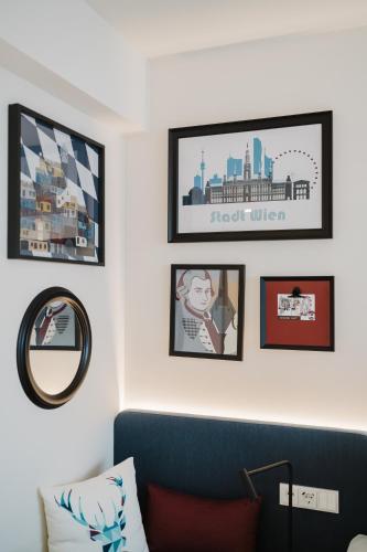 a living room with a blue couch and pictures on the wall at Hampton By Hilton Vienna City West in Vienna