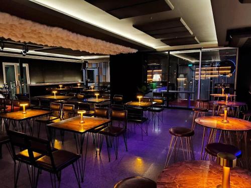 a dining room with tables and chairs and candles at Bay Hotel Srinakarin in Bangna