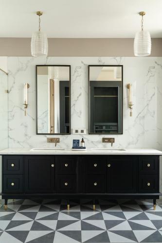 a bathroom with two sinks and two mirrors at LohonoStays Villa Lanai in Arpora