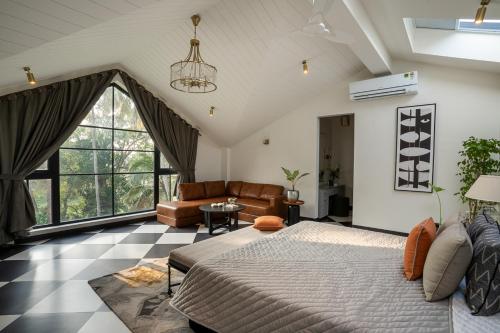 Un dormitorio con una cama grande y un sofá. en LohonoStays Villa Lanai, en Arpora