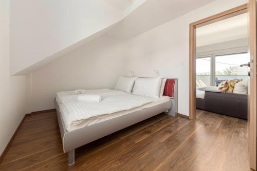 une chambre blanche avec un lit et un grand miroir dans l'établissement Frida's Place Ljubljana, à Ljubljana