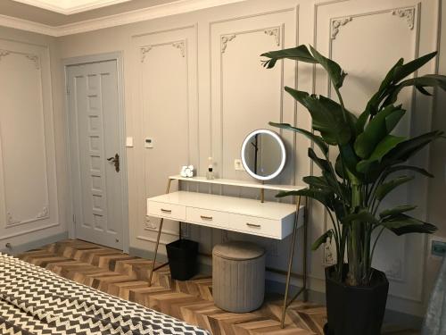 Un baño con lavabo, espejo y una planta. en Chongqing Liangjiang Yunshangjiangjing B&B, en Chongqing