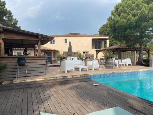 - une piscine avec des tables et des chaises à côté d'une maison dans l'établissement Studio 47 Cala Rossa Porto Vecchio, à Lecci