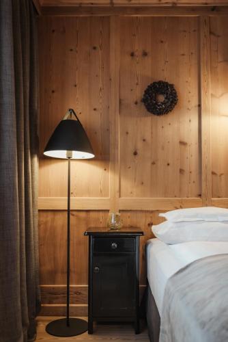 a bedroom with a bed and a lamp on a table at Hotel Antines in La Villa